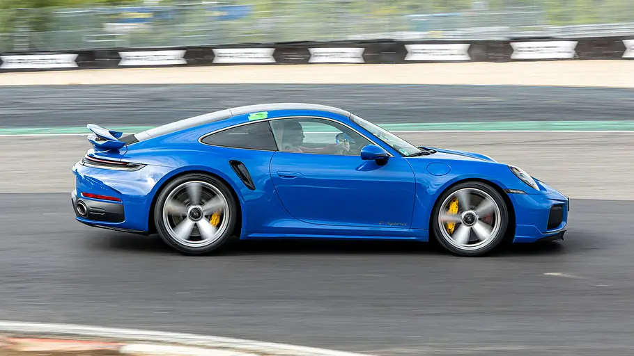 Der Porsche 911 Turbo S fährt auf dem Nürburgring, von rechts fotografiert.