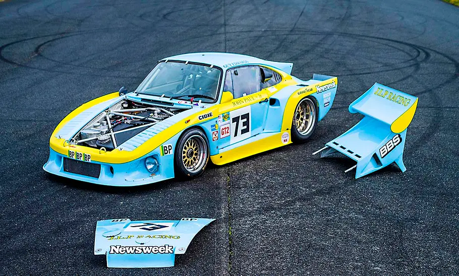 Der Porsche 935 steht mit abgebauten Hauben auf einer Asphaltfläche.