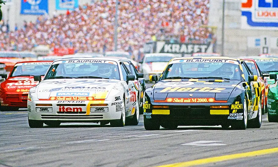 Porsche 944 Turbo Cup Blick von vorne auf eine Gruppe fahrender Porsche 944 Turbo Cup während eines Rennens.