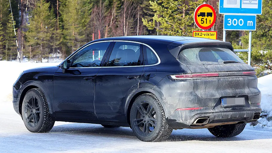 Porsche Cayenne Facelift (2026) Blick von schräg hinten auf das fahrende Porsche Cayenne Facelift (2026).