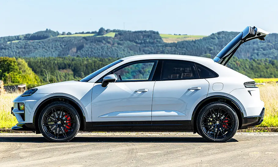 Der stehende Porsche Macan Turbo von der Seite mit offener Heckklappe.