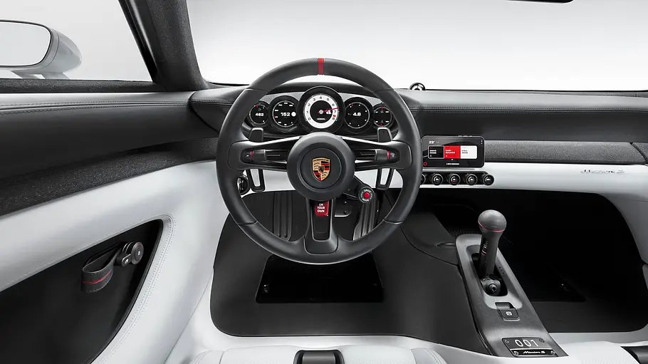 Das Cockpit des Porsche Mission S mit schwarzem Lenkrad und hellen Sitzen..