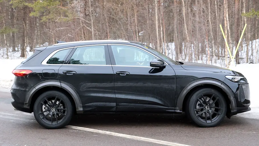 Der Porsche Octan fährt als Mule mir der Karosserie es Audi Q5 auf einer Landstraße, von rechts fotografiert.