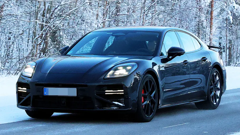 Porsche Panamera Facelift (2026) Blick von schräg vorne auf den fahrenden Erlkönig des Porsche Panamera Facelift (2026).