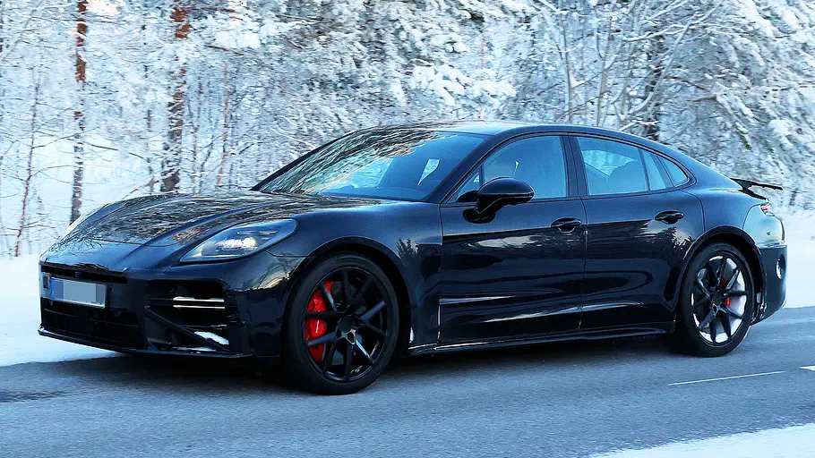 Porsche Panamera Facelift (2026) Blick von schräg vorne auf den fahrenden Erlkönig des Porsche Panamera Facelift (2026).