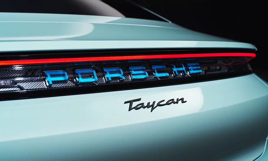 Porsche Taycan Facelift (2024) Detailbild des Porsche Taycan Facelift (2024) zeigt die Lichtleiste am Heck mit Porsche- und Taycan-Schriftzug.