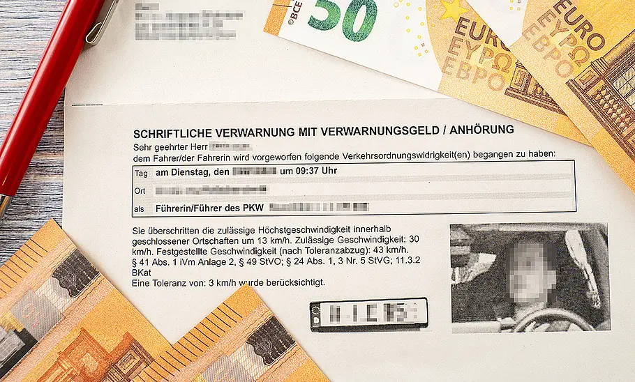 Ein Bußgeldbescheid mit Blitzerfoto. Am Rande des Bildes sind 50-Euro-Geldscheine zu sehen.