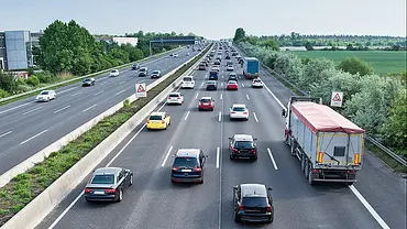 Eine stark befahrene vierspurige Autobahn aus erhöhter Perspektive in Fahrtrichtung fotografiert. - Foto: BauerStock