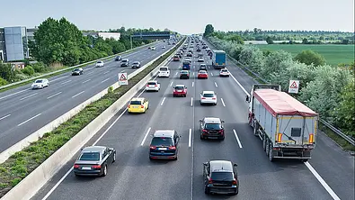 Eine stark befahrene vierspurige Autobahn aus erhöhter Perspektive in Fahrtrichtung fotografiert. - Foto: BauerStock