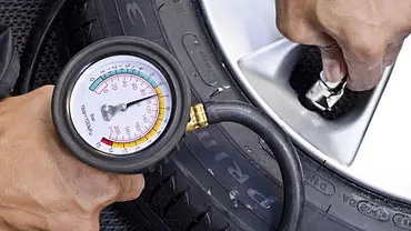 Tester mit einem Manometer beim Überprüfen des Reifendrucks, fotografiert von der Seite. - Foto: AUTO ZEITUNG Tester mit einem Manometer beim Überprüfen des Reifendrucks, fotografiert von der Seite. - Foto: AUTO ZEITUNG