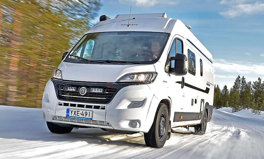 Das Bild zeigt ein Wohnmobil der Marke Hobby auf einer verschneiten Straße in Finnland während des Reifentests.
