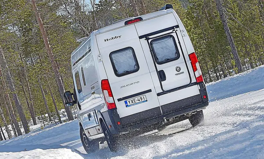 Das Bild zeigt den Ablauf des Traktionstests. Zu sehen das Wohnmobil, das auf verschneiter Straße eine Kurve fährt.