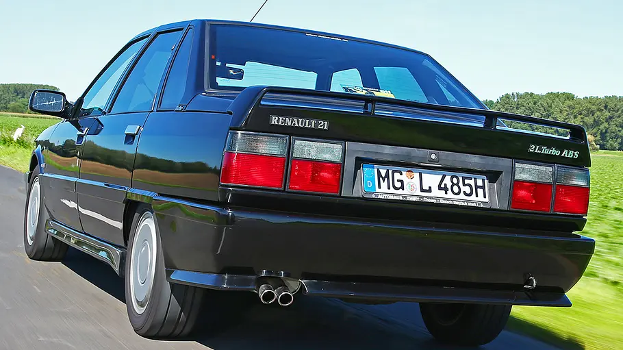 Der Renault 21 Turbo fahrend von schräg hinten