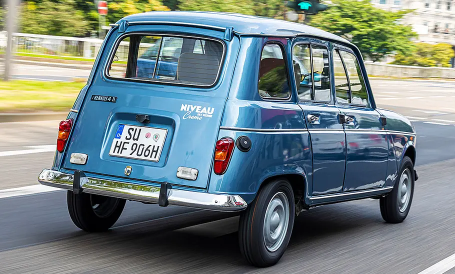 Der Renault 4 fahrend von schräg hinten fotografiert.