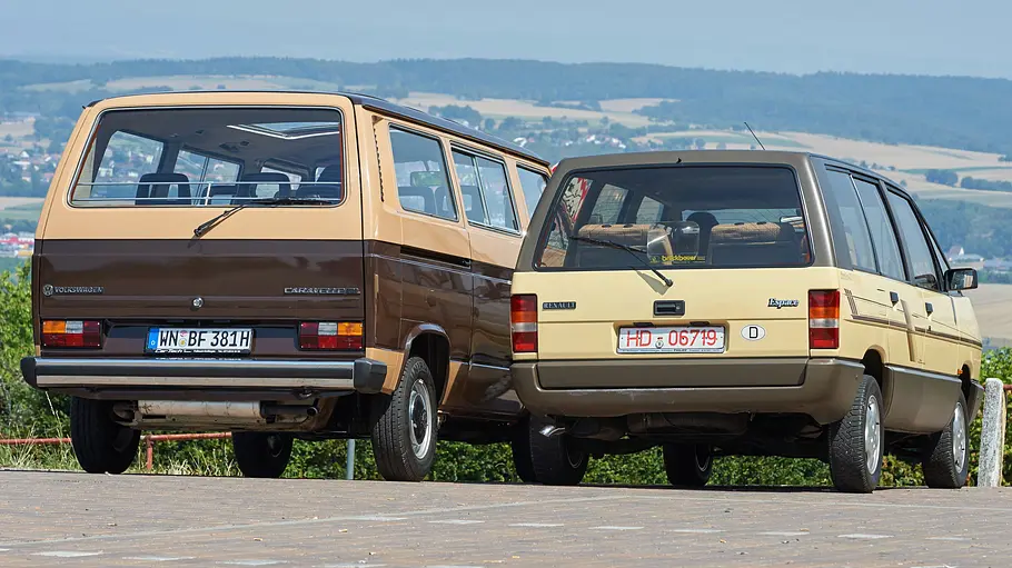 Der VW T3 Caravelle und Renault Espace stehen nebeneinander, fotografiert von hinten.