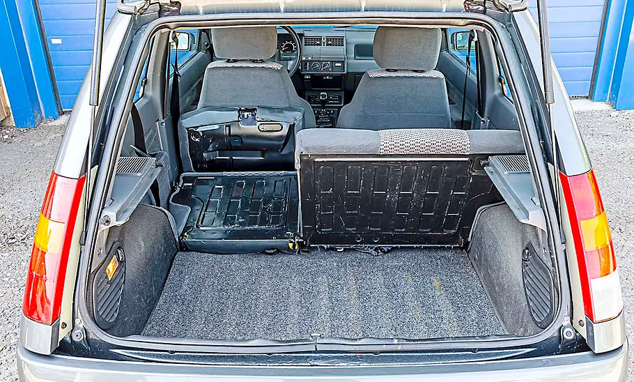 Renault 5 Man sieht vom Renault 5 den Kofferraum mit einem umgeklappten Sitz.