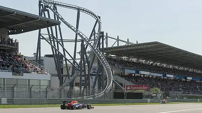 Ein Rennfahrzeug vor dem Ring Racer, daneben sieht man die Tribüne des Nürburginges. - Foto: Imago