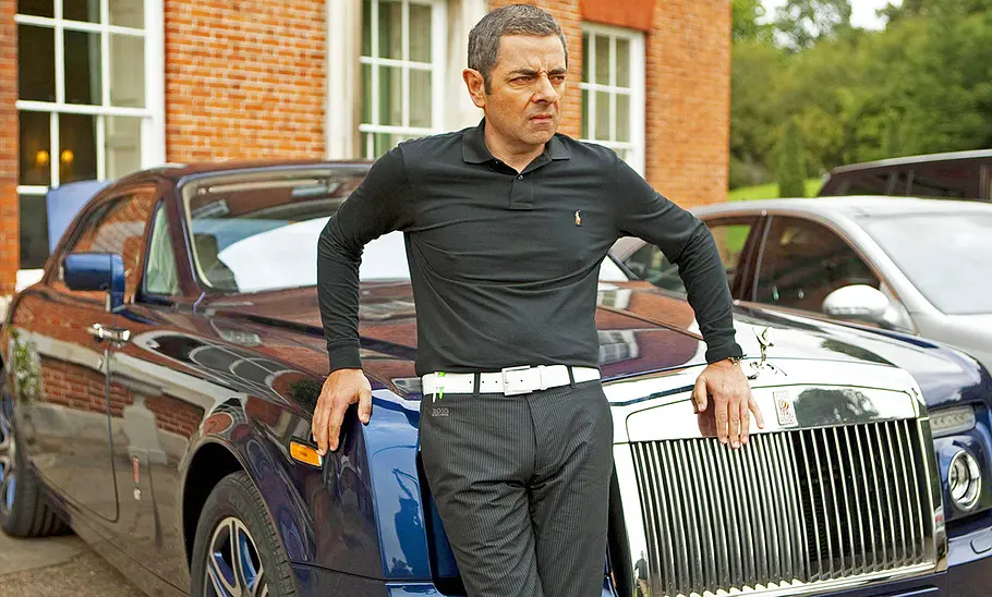 Rowan Atkinson steht vor dem Rolls-Royce Phantom Drophead.