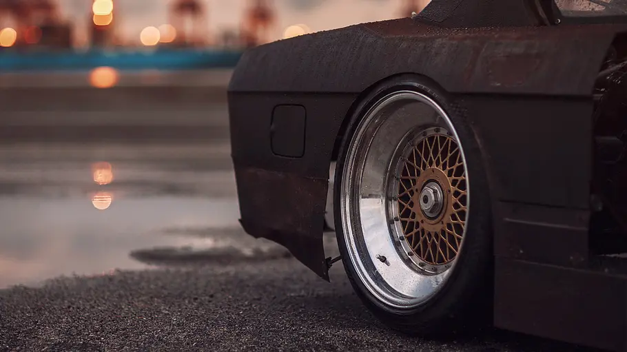 Hinterrad von BMW E28 Rusty Slammington, fotografiert von der Seite.