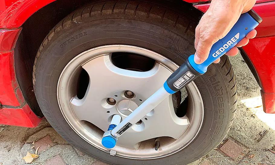 Der Gedore TORCOFIX TF-K Drehmomentschlüssel an einem Autoreifen.