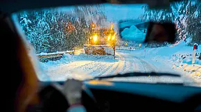 Ein Auto fährt einem Schneepflug entgegen in verschneiter Landschaft. - Foto: iStock Ein Auto fährt einem Schneepflug entgegen in verschneiter Landschaft. - Foto: iStock