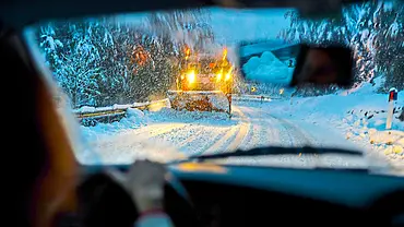 Ein Auto fährt einem Schneepflug entgegen in verschneiter Landschaft. - Foto: iStock Ein Auto fährt einem Schneepflug entgegen in verschneiter Landschaft. - Foto: iStock
