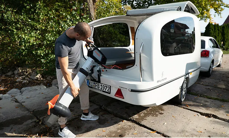 Sealander (2024) Ein Mann lädt einen Elektro-Außenborder in den Sealander.