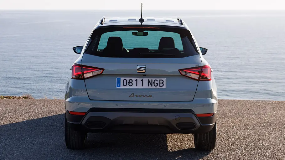 Das Seat Arona Facelift steht an einer Küste, von hinten fotografiert.