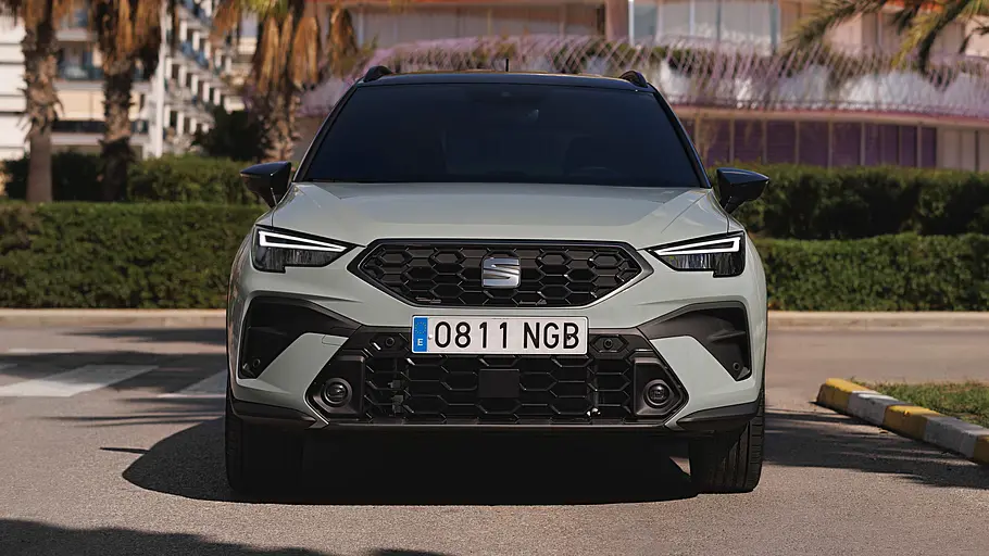 Das Seat Arona Facelift steht auf einem Parkplatz, von vorne fotografiert.
