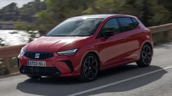 Der Seat Ibiza fährt über eine Landstraße, fotografiert von schräg vorne. - Foto: Seat