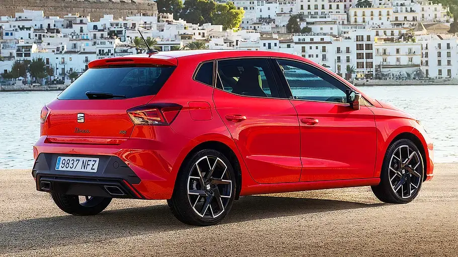 Seat Ibiza Facelift (2026) Der Seat Ibiza steht vor einer Hafenkulisse, fotografiert von schräg hinten.