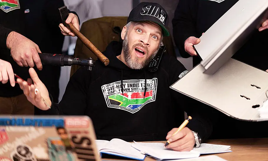 Sidney Hoffmann am Schreibtisch sitzend fotografiert.