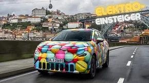 Skoda Epiq als getarntes Vorserienfahrzeug fahrend mit Stadt Porto im Hintergrund. - Foto: AUTO ZEITUNG