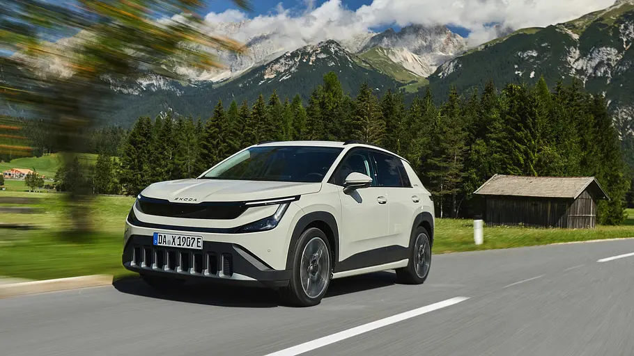 Skoda Epiq Weißer Skoda Epiq von schräg vorn fahrend vor einer Berglandschaft