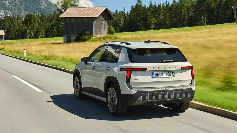 Skoda Epiq Weißer Skoda Epiq von schräg hinten fahrend vor einer Berglandschaft
