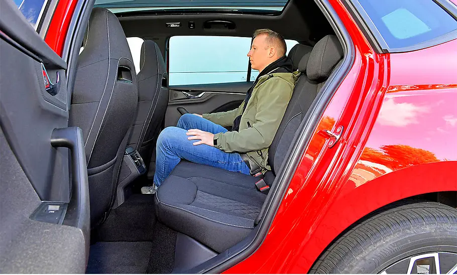 Ein Testredakteur beim Probesitzen auf der Rückbank des Skoda Kamiq (2019).
