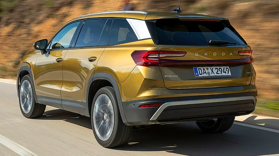 Skoda Kodiaq Der Skoda Kodiaq fährt auf einer Bergstraße, von hinten links fotografiert.