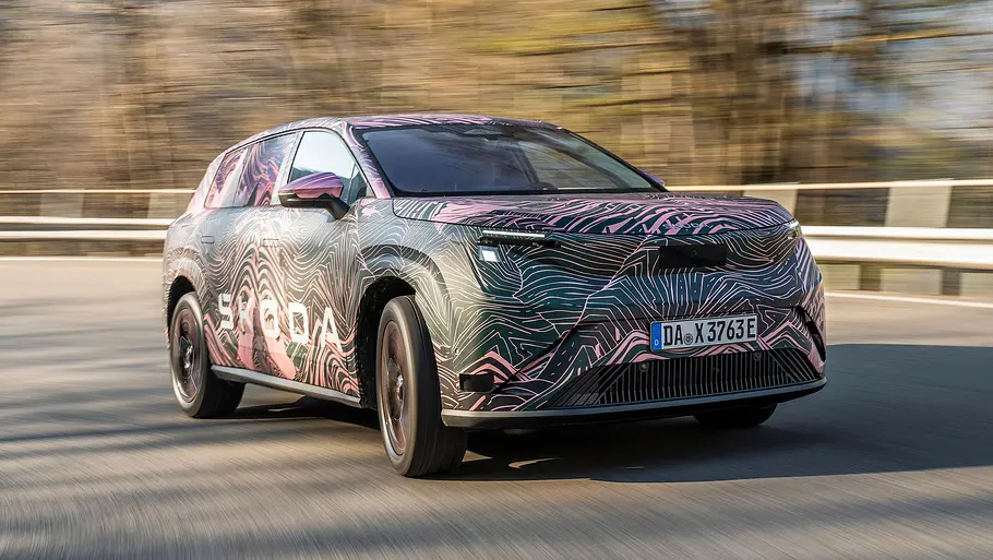 Skoda Peaq Der Skoda Peaq fahrend von schräg vorne abgebildet und getarnt.