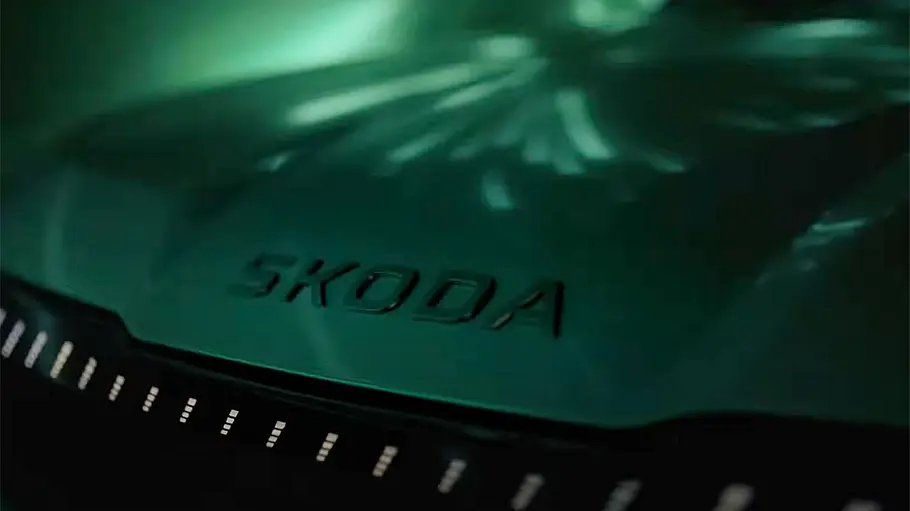 Skoda Peaq (2026) Ein dunkel gehaltenes Teaserfoto des Skoda Peaq, das Logo an der Front in der Detailaufnahme.