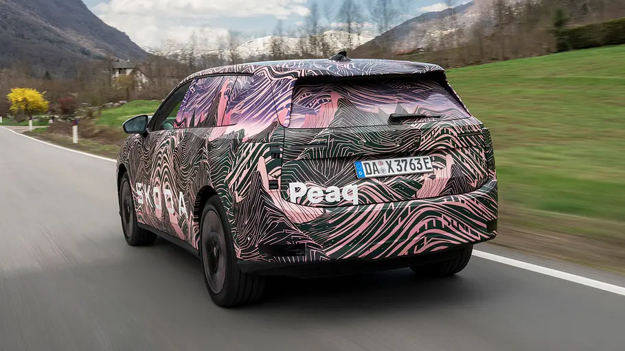Der Skoda Peaq fährt auf einer Landstraße, von hinten fotografiert.