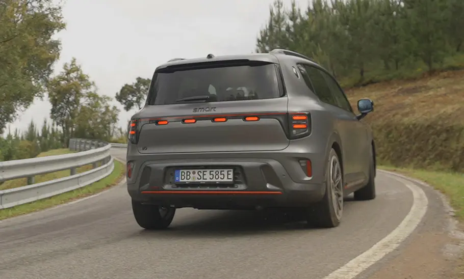 Smart #5 Brabus (2025) Smart #5 Brabus (2025) fährt um die Kurve von schräg hinten fotografiert.