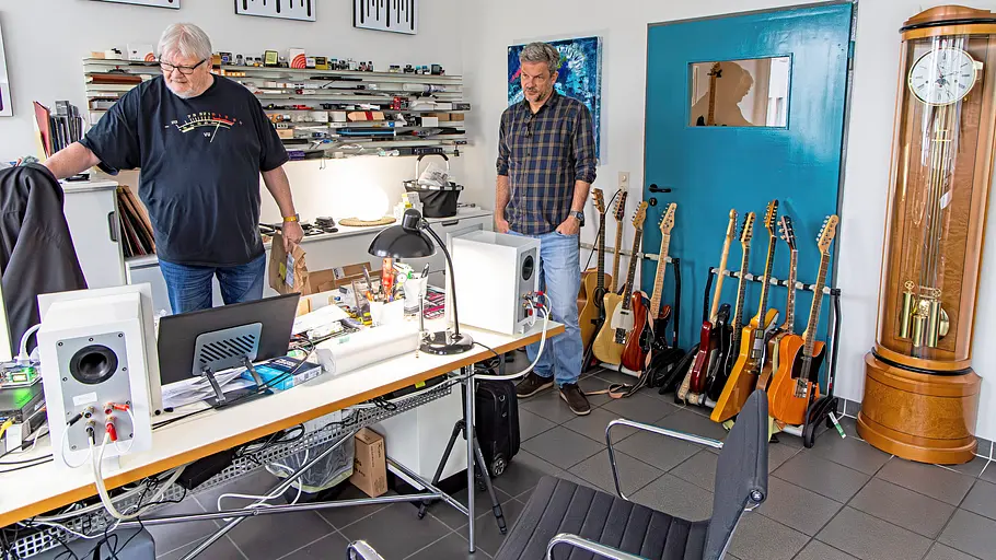 Zwei Personen stehend in einem Büro fotografiert.