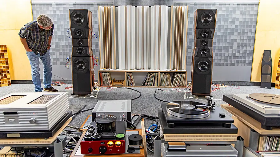 Eine Person stehend neben einem Indoor-Soundsystem fotografiert.
