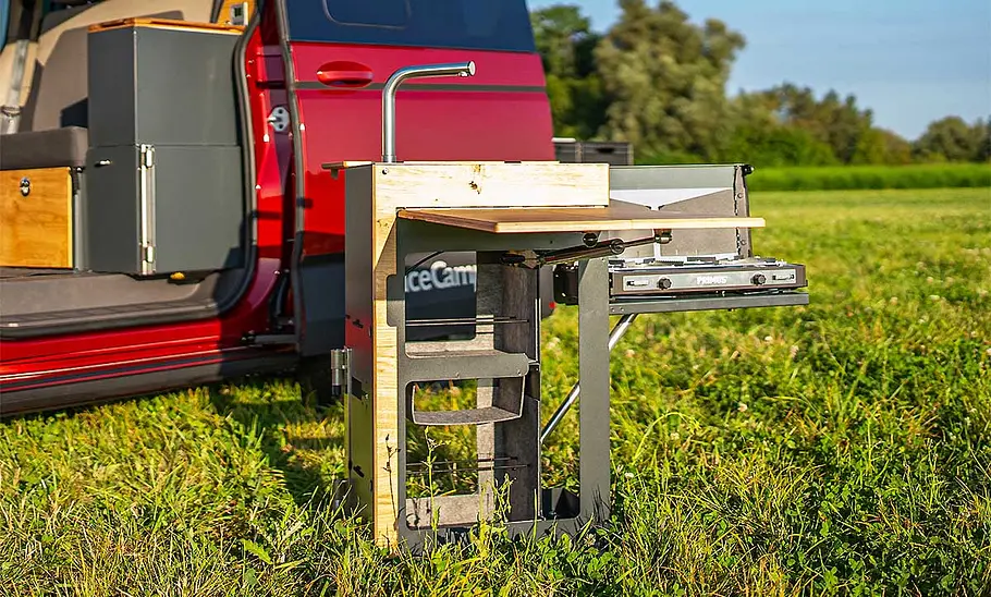 Spacecamper Classic+ Multivan (2025) Die Außenaufnahme zeigt das Küchenmodul im Spacecamper Classic+ Multivan (2025) vor dem Camper stehend.