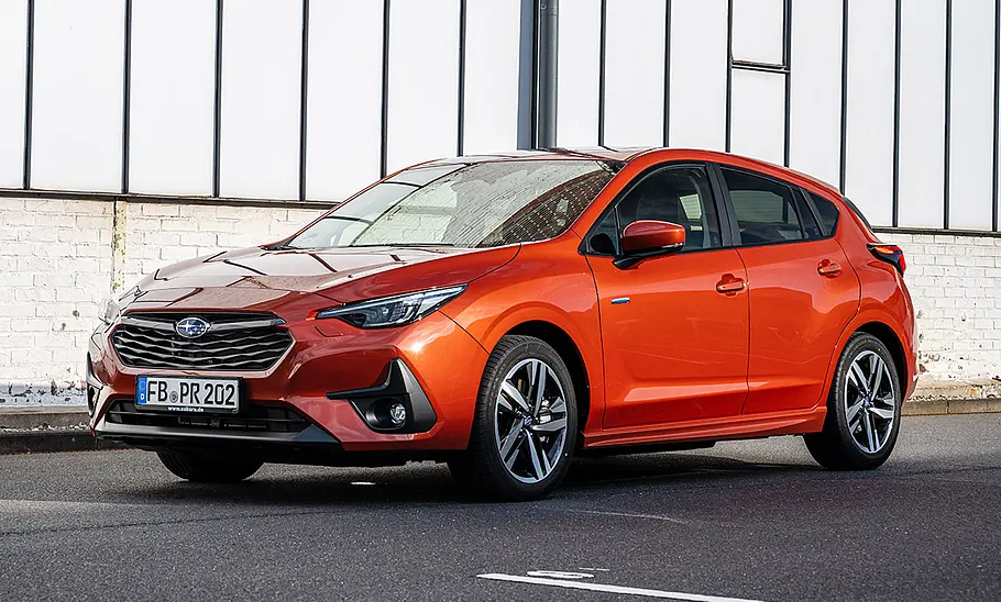 Subaru Impreza steht vor einer Hallenwand, Ansicht von vorne links.