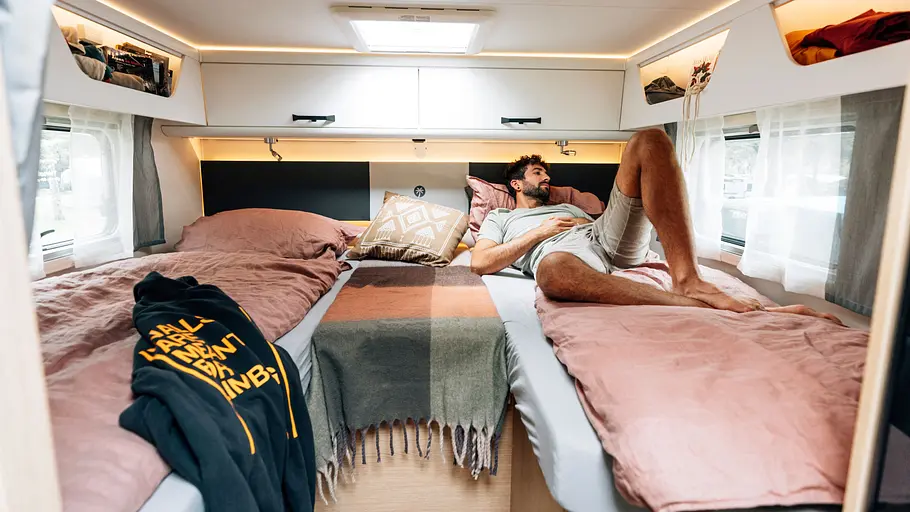Die Innenaufnahme zeigt einen Mann, der auf dem Bett im Schlafzimmer des Sunlight T 66 S (2026) liegt.