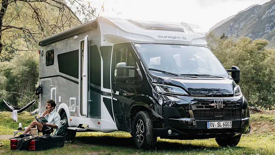 Der stehende Sunlight T 66 S (2026), Sondermodell Adventure, von schräg vorne aufgenommen. Davor sitzt ein Mann und liest.