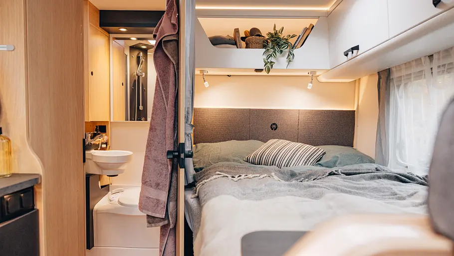 Die Innenaufnahme zeigt das Heckbett und das Badezimmer im Sunlight T58.