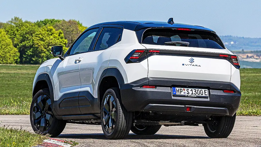Suzuki e Vitara Blick von schräg hinten auf den fahrenden Suzuki e Vitara.