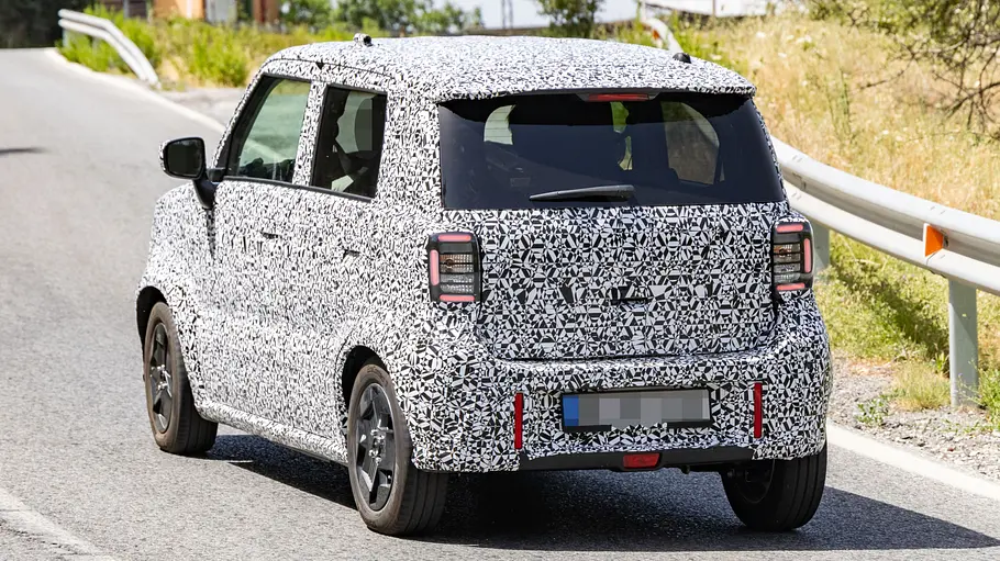 Suzuki Elektro-Kei-Car Der Erlkönig des Suzuki Elektro-Kei-Car fahrend von schräg hinten links.